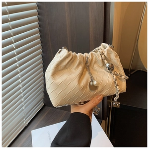 Detail of cream woven shoulder bag with silver chain, large pearls, and metal ball charm