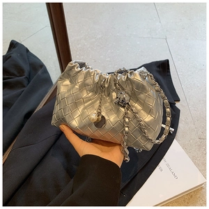 Detail of silver woven texture bag featuring elegant pearl and metal ball charms