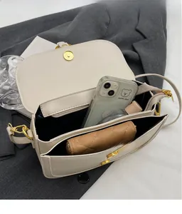 Detailed interior of a cream shoulder bag showing spacious storage for phone and wallet
