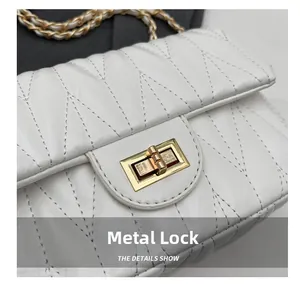 Close-up of elegant white quilted leather bag with golden hardware and metal chain strap