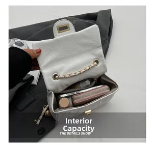 Macro view showing internal capacity of the quilted white chain bag with gold hardware