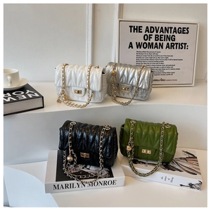Quilted crossbody bags in four colors with gold ball chain and metal turn-lock on display