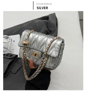 Detail of silver quilted chain bag with gold ball adjustment and twist lock closure