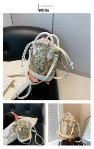 Detail view of the white sequin bucket bag with golden circular scales and chain strap