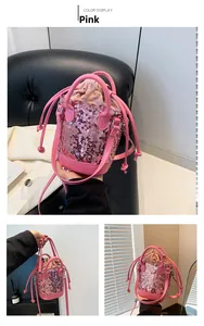 Detail of pink sequin bucket bag featuring drawstring closure and metallic chain strap
