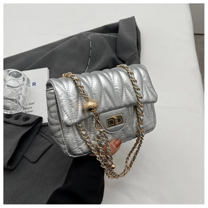 Detail of silver quilted mini bag with gold chain strap and adjustable golden ball