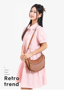 Brown leather crescent shoulder bag with litchi texture shown on a female model