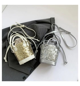Detail view of gold and silver sequin mini bucket bags with drawstring and chain strap