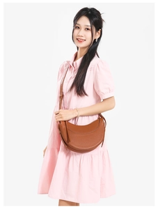 Close-up of brown crescent saddle bag in lychee pattern leather with wide shoulder strap