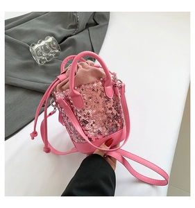 Detail of pink sequin bucket bag featuring a drawstring closure and versatile straps