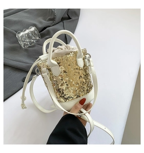 Detail of sequin bucket bag with gold circular sequins and white drawstring leather closure