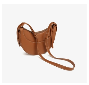 Détail du sac demi-lune en cuir marron avec surpiqûres blanches contrastées et zip argenté