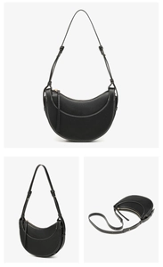 Detail of black crescent shoulder bag featuring contrast white stitching and leather strap
