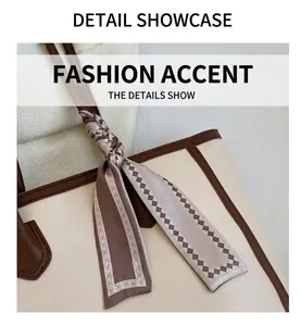 Detail shot of a beige tote bag handle with a patterned silk scarf and brown edges