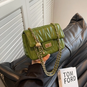 Emerald green quilted chain bag with glossy finish and gold spherical metal ornament