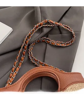 Detail of comfortable chain strap and woven texture on a stylish bucket bag