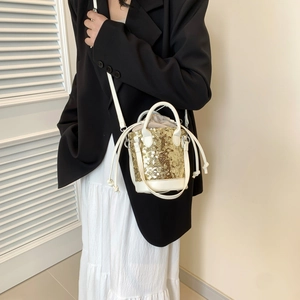 Golden sequin bucket bag with white leather straps and drawstring for modern women