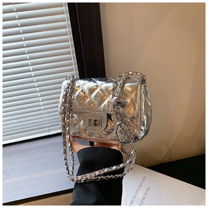 Close-up of silver quilted chain bag with laser-finish texture and metallic turn-lock