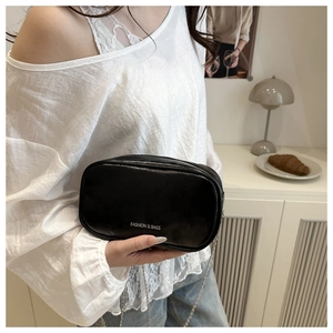 Detail view of black faux leather mini bag with silver chain strap and logo printing