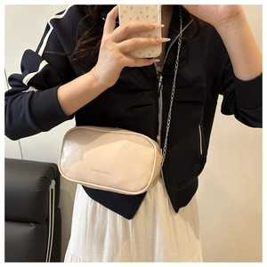Détail d'un sac carré chic en cuir PU abricot avec une fine chaîne en métal argenté