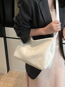 White minimalist PU leather tote bag for women shown as a crossbody on a model