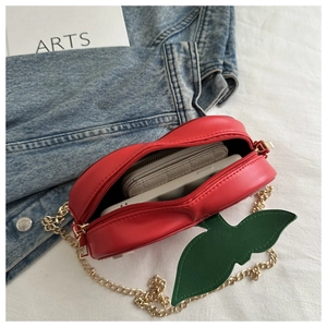 Detailed interior view of red cherry-shaped chain bag showing capacity for daily essentials