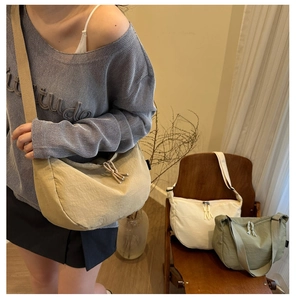 Three semi-circle nylon bags in khaki, white, and olive green with wide straps