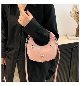 Dettaglio borsa a mezzaluna rosa con sfere di metallo argento e tracolla regolabile