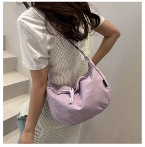 Detailed view of the pleated nylon lavender crescent bag showing its capacity on model
