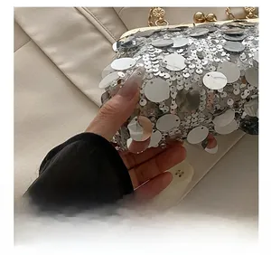 Close-up of silver sequins and vintage-style metal clasp on a stylish evening clutch bag