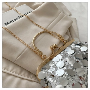 Detail of silver sequin evening bag with engraved gold frame and delicate chain strap
