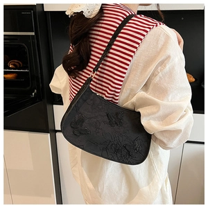 Dettaglio borsa sottobraccio nera con tre rilievi farfalla 3D e texture plissettata