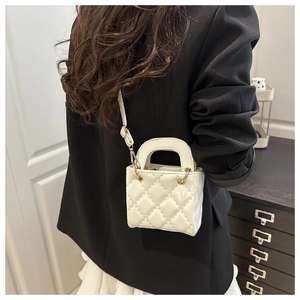 Detailed back view of a white quilted mini bag with gold chain strap on a model
