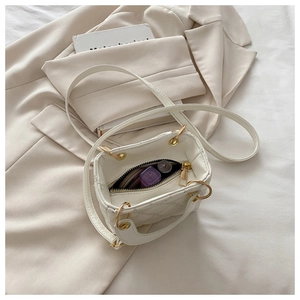 Interior view of white quilted mini bag showing space for lipstick and makeup compact