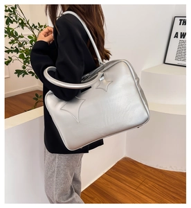 Silver metallic tote bag with star patches shown on a model for casual daily use
