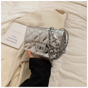 Close-up of silver quilted chain bag with metallic finish and turn-lock closure