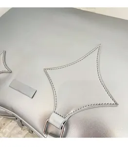 Detail of silver matte briefcase featuring star stitching and polished metal buckle