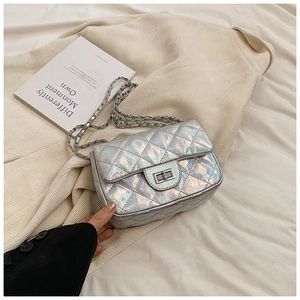 Detail of laser silver quilted shoulder bag with metal chain strap and turn-lock closure