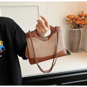 Detail view of woven leather bucket bag with silver twist lock and round cutout handle
