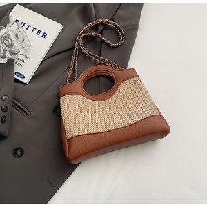 Detail of a bucket bag with brown leather, beige woven texture, and chain strap