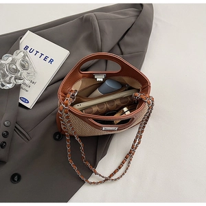 Detail of a color-block bucket bag showing storage for phone and wallet with chain strap