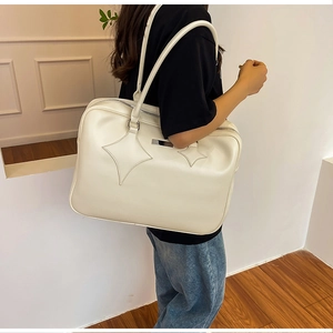 Close-up of beige PU leather tote bag with star stitching details and long shoulder straps