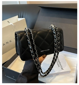 Detail of black quilted leather shoulder bag with silver chain strap and fashion logo