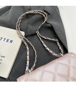 Detailed view of pink quilted leather crossbody bag with silver woven chain strap