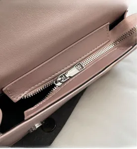 Detailed macro shot of smooth silver zipper and pink leather lining on the interior pocket