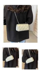 Detail of a beige quilted crossbody bag with silver chain strap worn over a black blazer