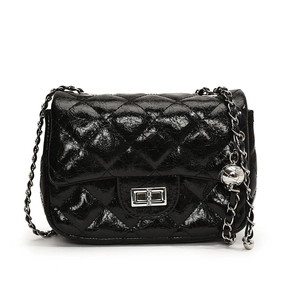 Glossy black quilted crossbody bag with silver chain strap and metal ball ornament