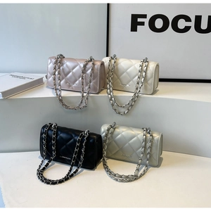 Detail shot of multi-color quilted chain bags with metal logo lettering on display