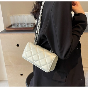 Detail shot of silver quilted flap bag featuring a chain strap and metal logo lettering