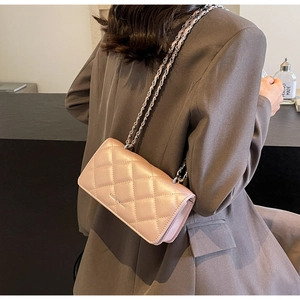Quilted diamond pattern crossbody bag with chain strap shown on a model for scale